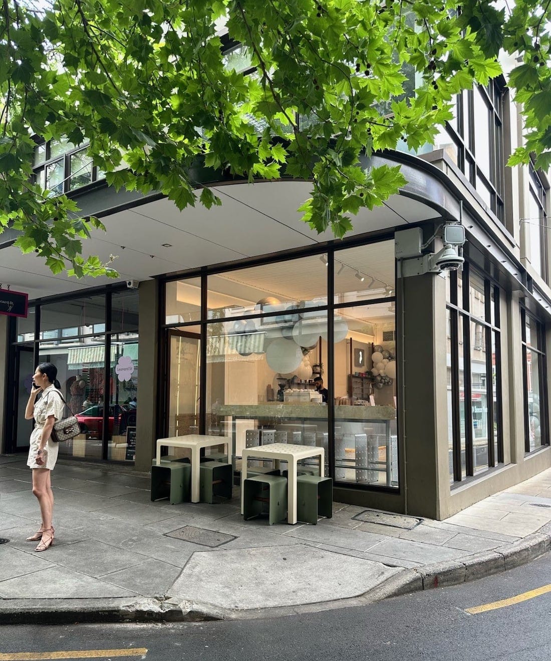 The OVO Gelato shopfront on the corner of Ebenezer Place in Adelaide's East End, with sage green stools under a leafy plane tree